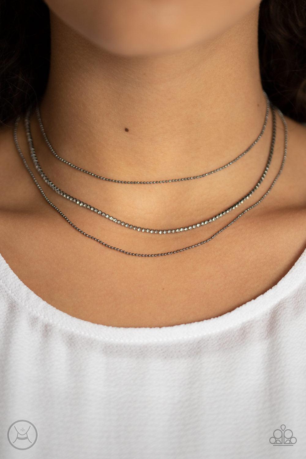 Paparazzi Accessories Battle Of The Glitz - Black Two strands of dainty gunmetal ball chain join a glittery strand of glassy white rhinestones around the neck, creating glittery layers. Features an adjustable clasp closure. Jewelry