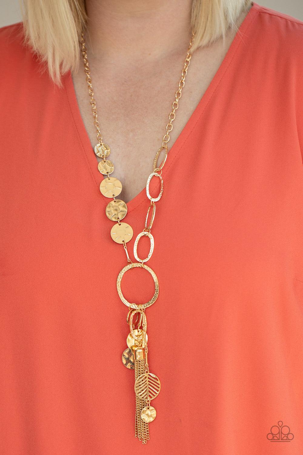 Paparazzi Accessories Trinket Trent ~Gold One row of hammered gold discs and one row of hammered oval links give way to an oversized hammered gold hoop. A collection of gold discs, hammered links, abstract gold pieces, and a shimmery gold chain tassel dan