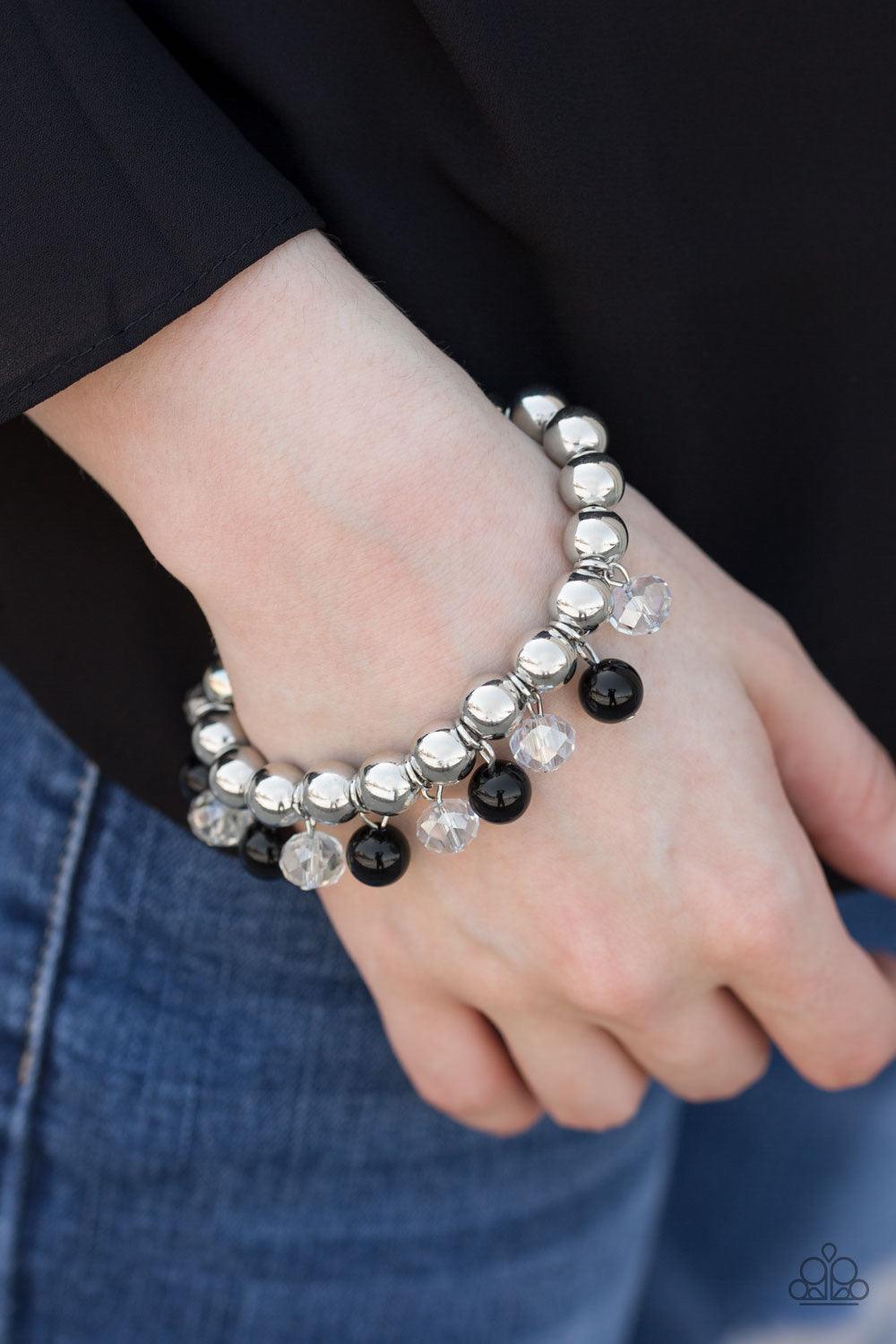 Paparazzi Accessories Once In A Millennium - Black Shiny silver beads are threaded along an elastic stretchy band. Shiny black beads and glassy crystal-like beads swing from the wrist for a refined look. Sold as one individual bracelet. Jewelry