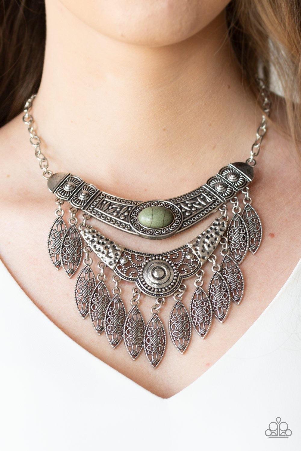 Paparazzi Accessories Island Queen - Green Featuring a collision of hammered, studded, and embossed patterns, two silver half-moon plates dramatically stack below the collar. Swirling with studded filigree detail, ornate silver frames swing from the botto