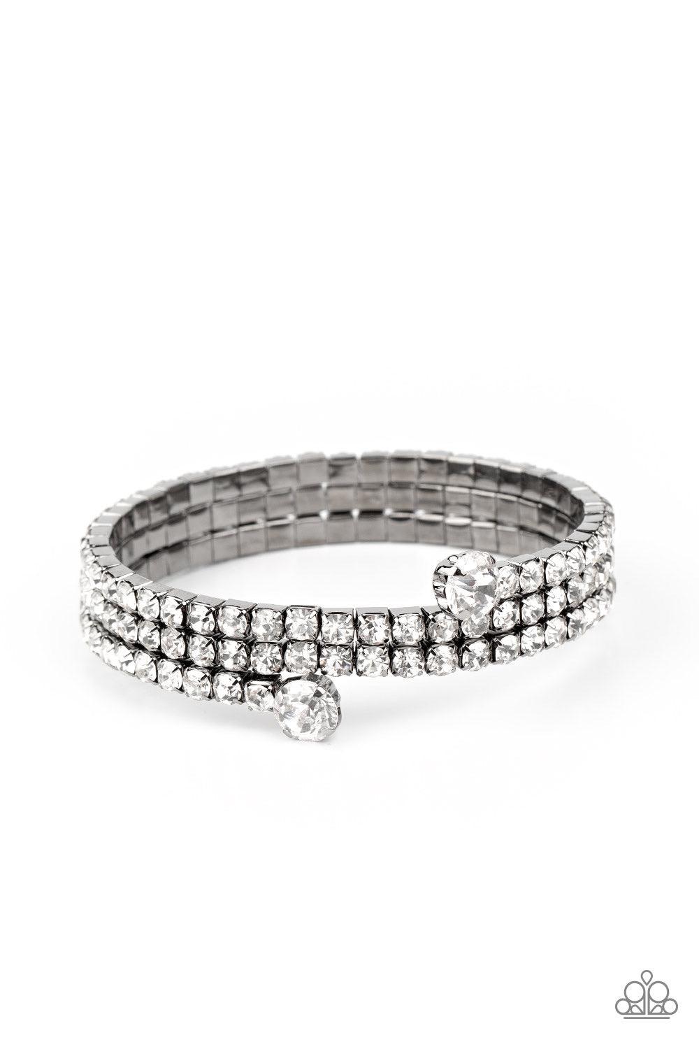 Paparazzi Accessories After Party Princess - Black Featuring two oversized white rhinestone fittings, a glittery collection of white rhinestone encrusted gunmetal frames are threaded along a gunmetal wire around the wrist, creating a glamorous infinity wr