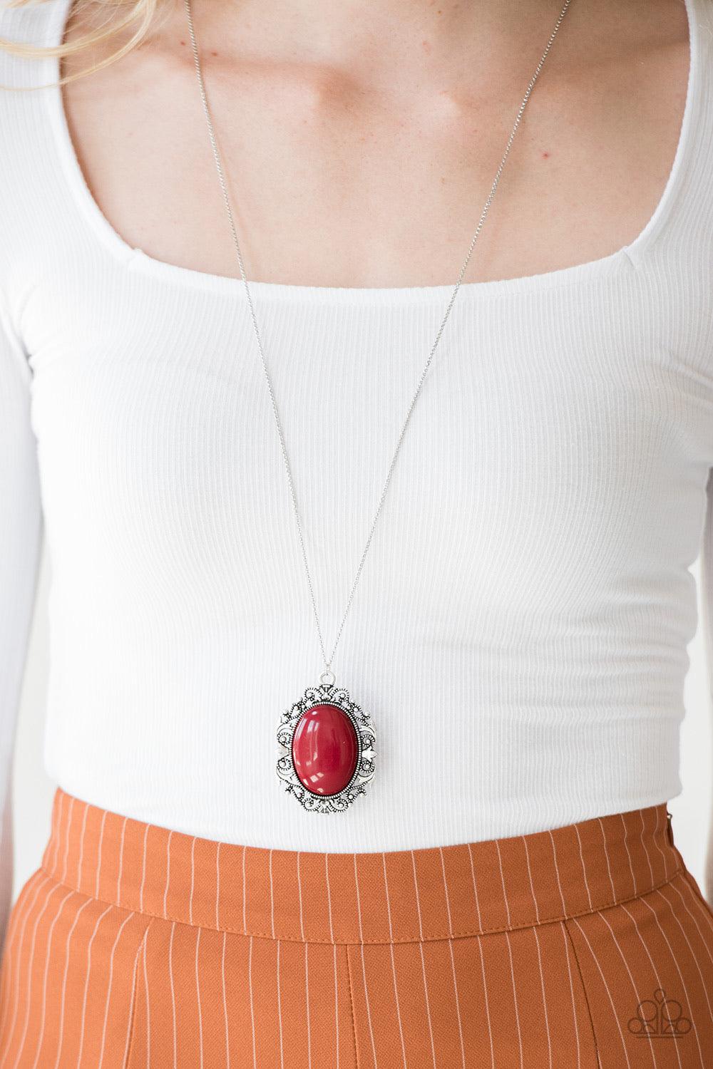 Paparazzi Accessories Vintage Vanity ~Red Featuring a faux rock finish, a robust red bead is pressed into the center of a frilly silver frame radiating with studded details. The dramatic pendant swings from the bottom of a lengthened silver chain for a vi