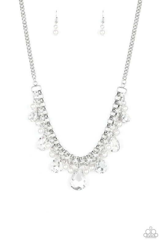 Paparazzi Accessories Knockout Queen - White A glamorous collection of bubbly white pearls and exaggerated white teardrop gems dangle from a bold strand of white rhinestones, creating a knockout fringe below the collar. Features an adjustable clasp closur
