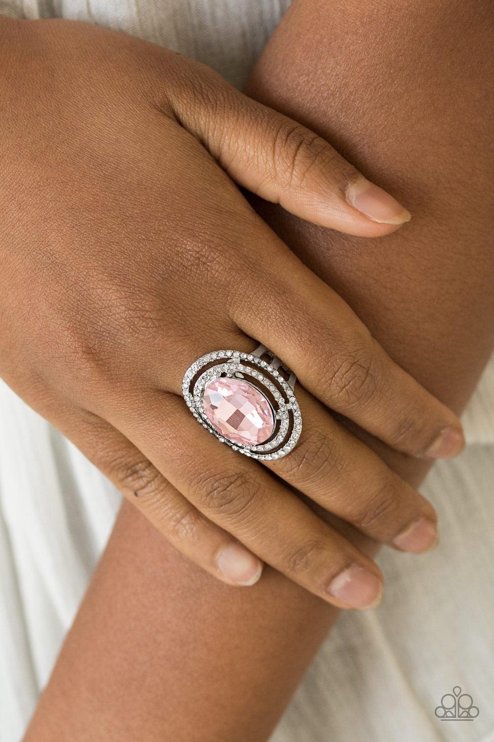 Paparazzi Accessories Making History - Pink A glittery pink gem sits atop stacked silver frames radiating with glassy white rhinestones for a timeless look. Features a stretchy band for a flexible fit. Sold as one individual ring. Jewelry