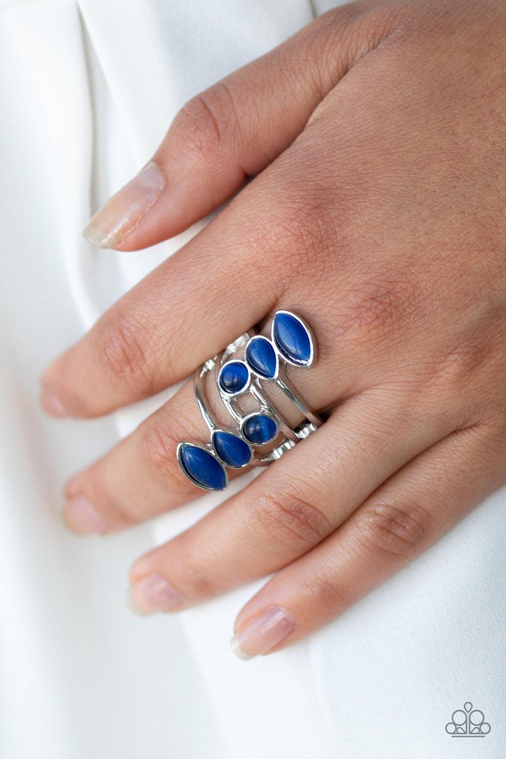 Paparazzi Accessories Wraparound Radiance ~Blue Featuring round, teardrop, and marquise shapes, two frames of glowing blue cat's eye stones stack across a layered silver band for an all around radiance. Features a stretchy band for a flexible fit.