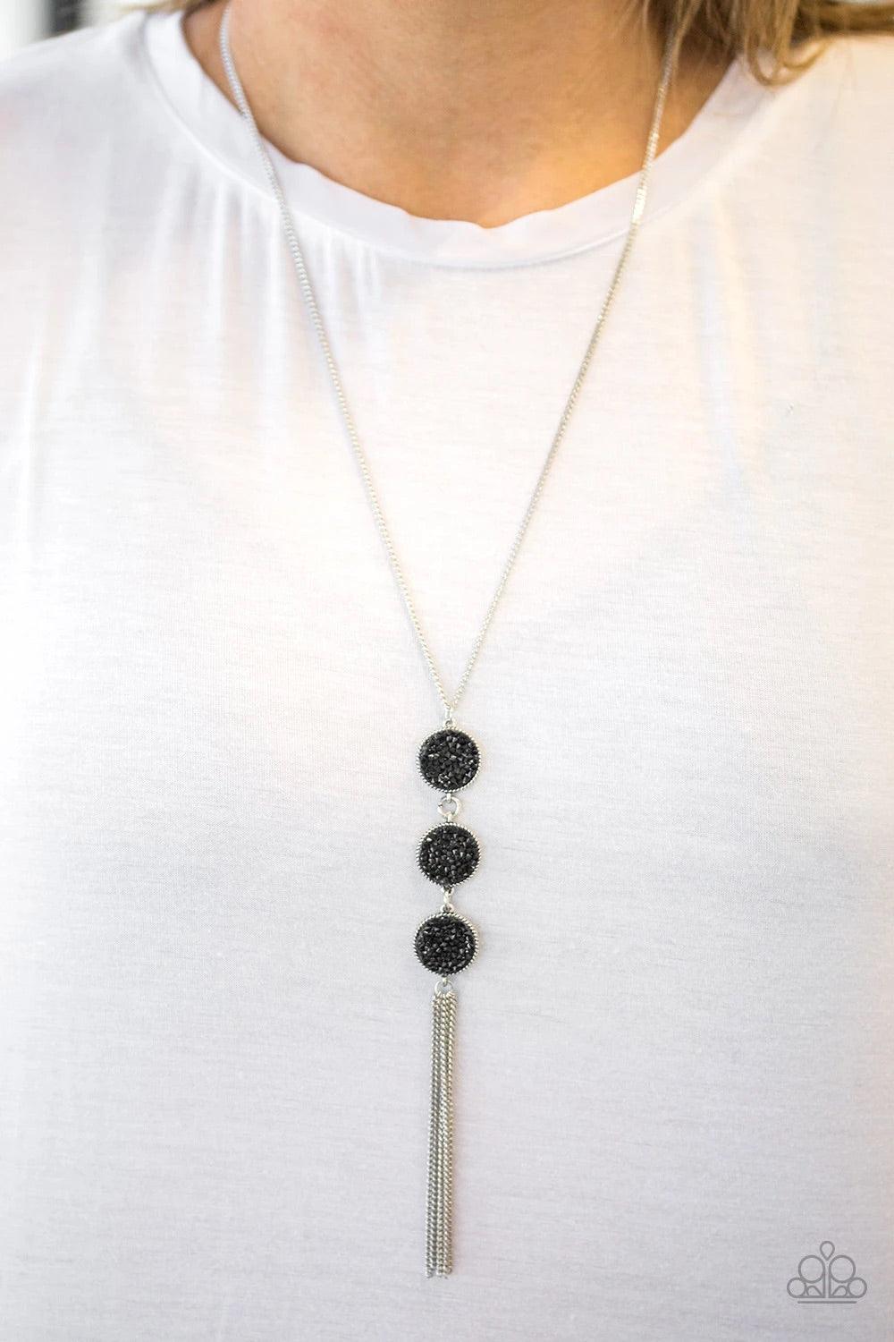 Paparazzi Accessories Triple Shimmer - Black Sprinkled in glittery black prism style rhinestones, three sparkling silver frames trickle down the chest. A shimmery silver tassel swings from the bottom of the triple stacked pendant for a glamorous finish. F