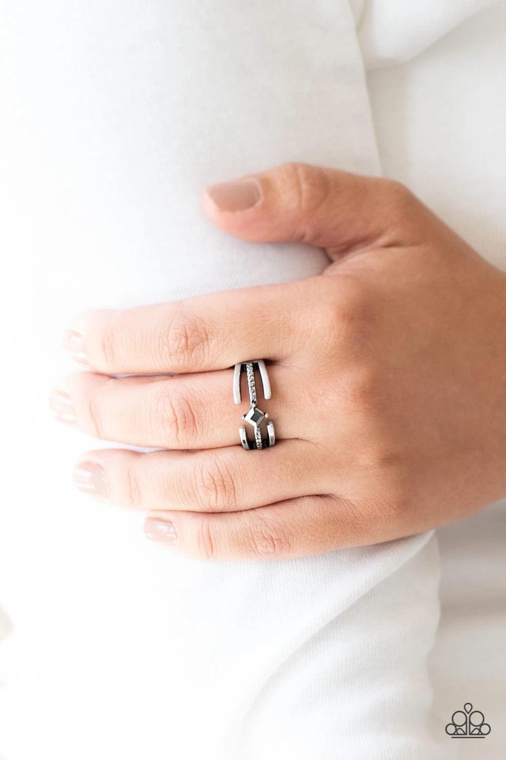 Paparazzi Accessories City Center - Silver Glistening silver bars gather around a sparkling hematite rhinestone encrusted band. Featuring a regal square cut, a hematite rhinestone is pressed into the center for an edgy finish. Features a dainty stretchy b