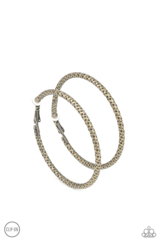 Paparazzi Accessories Subtly Sassy - Brass *Clip-On An oversized brass hoop featuring a porous-like texture sends off a subtle shimmer as it wraps around the ear. Earring attaches to a standard clip-on fitting. Hoop measures approximately 2" in diameter.