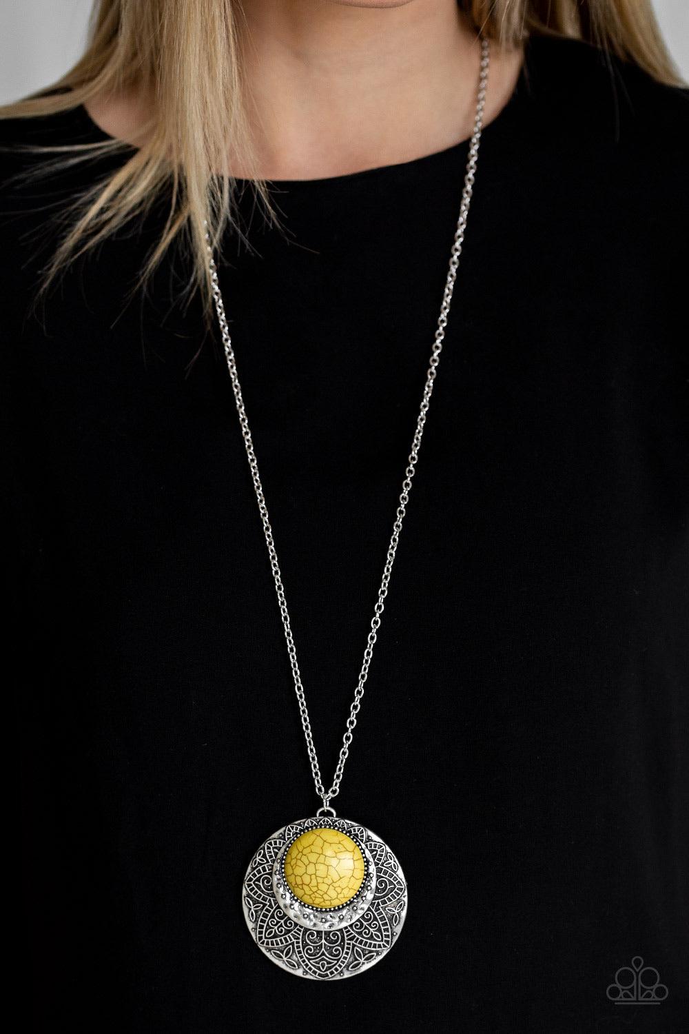 Paparazzi Accessories Medallion Meadow - Yellow Swinging from the bottom of a lengthened silver chain, a sunny yellow stone is pressed into a hammered silver medallion radiating with floral details for a bold tribal inspired look. Features an adjustable c