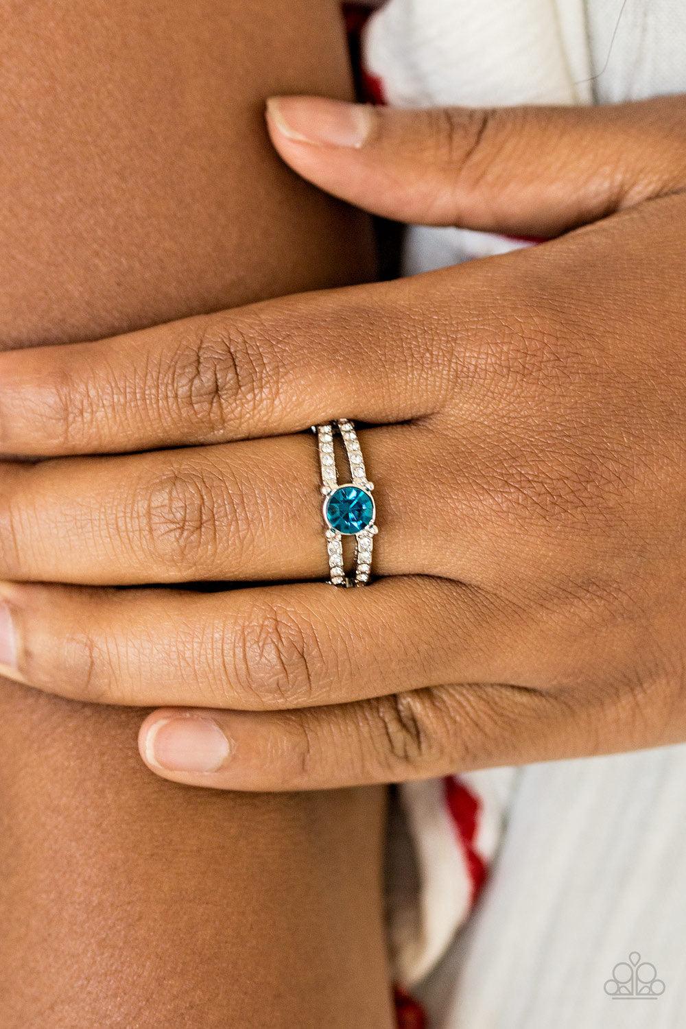 Paparazzi Accessories Dream Sparkle - Blue A glittery blue rhinestone sits atop two shimmery silver bands encrusted in glassy white rhinestones for a glamorous look. Features a dainty stretchy band for a flexible fit. Jewelry