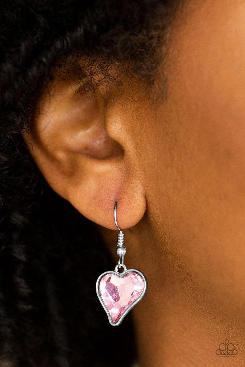 Paparazzi Accessories Princeton Princess - Pink Cut into a whimsical heart shape, a glittery pink gem swings from the bottom of a glistening silver chain below the collar for a charming look. Features a toggle closure. Jewelry