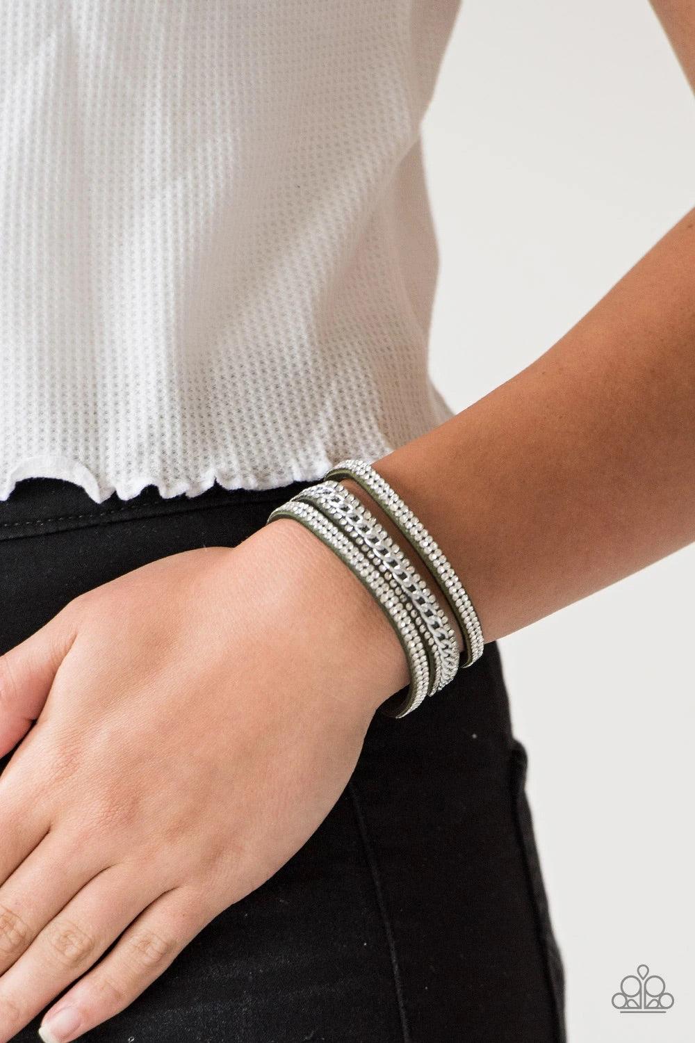 Paparazzi Accessories Rollin In Rhinestones - Green Rows of glassy white rhinestones and a shimmery silver chain are encrusted along green suede bands for a sassy look. Features an adjustable snap closure. Sold as one individual bracelet. Jewelry