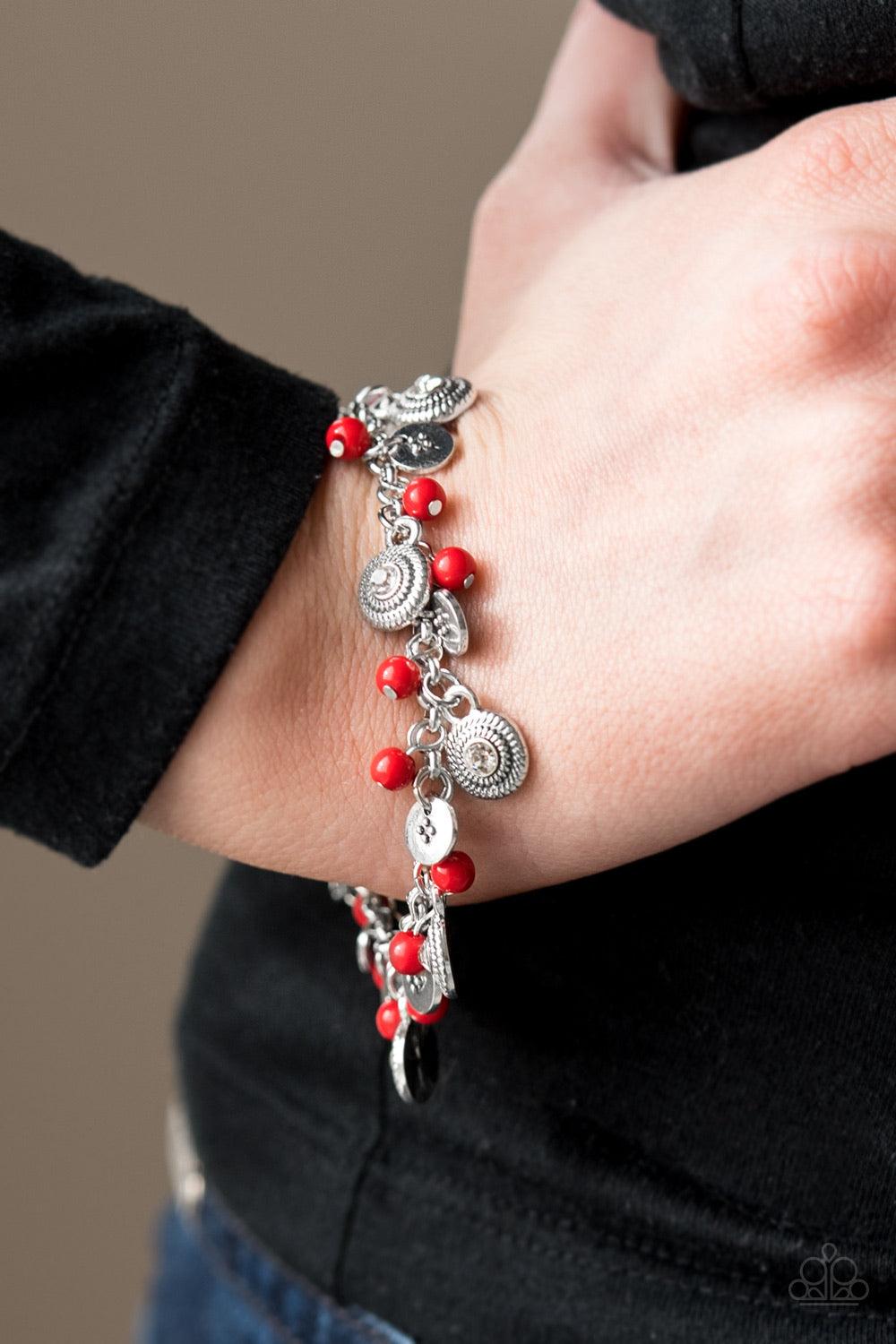 Paparazzi Accessories Pure LUXE - Red Dainty red beads and ornate silver discs swing from a shimmery silver chain, creating a casual fringe around the wrist. Featuring rhinestone centers, textured silver discs are sprinkled between refined beading for a g