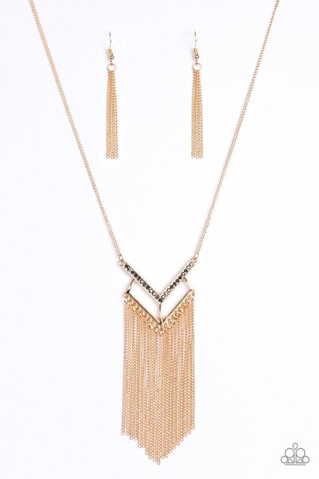 Paparazzi Accessories Alpha Glam - Gold Encrusted in hematite rhinestones, a V-shaped frame attaches to an airy gold frame, creating a stacked pendant. Swinging from the bottom of a lengthened gold chain, the glamorous pendant gives way to a tapered fring