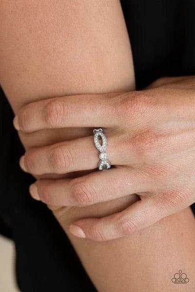 Paparazzi Accessories Extra Side of Elegance - White Encrusted in glassy white rhinestones, glistening silver ribbons loop away from a dazzling white rhinestone center for a refined look. Features a dainty stretchy band for a flexible fit. Sold as one ind