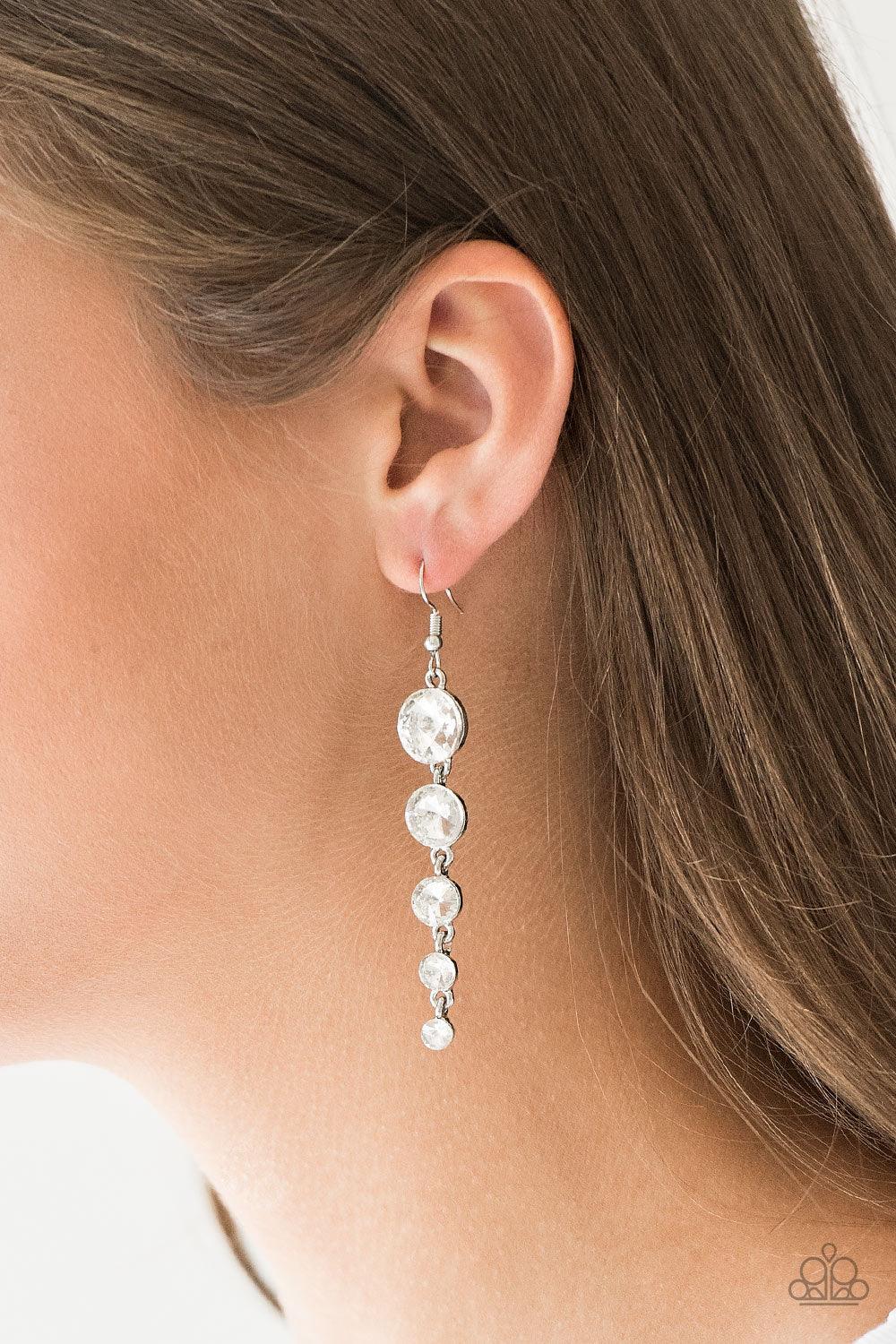 Paparazzi Accessories Raining Rhinestones - White Gradually decreasing in size, glassy white rhinestones trickle from the ear, coalescing into a glamorous lure. Earring attaches to a standard fishhook fitting. Sold as one pair of earrings. Jewelry