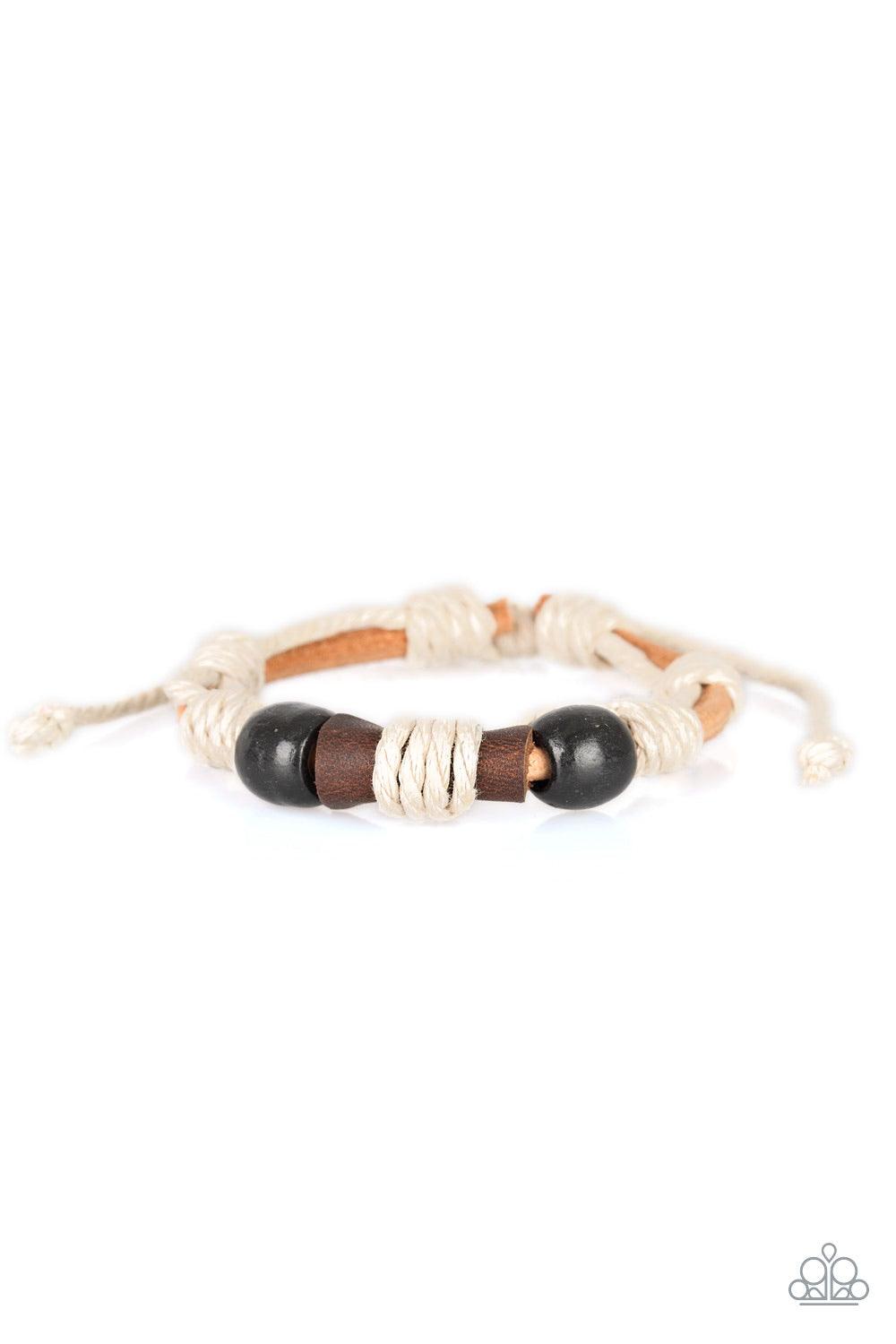 Paparazzi Accessories Back In The Backwoods - Black Earthy wooden beads and a piece of rolled leather is knotted across the front of a strand of brown suede cording for a seasonal flair. Features an adjustable sliding knot closure. Sold as one individual
