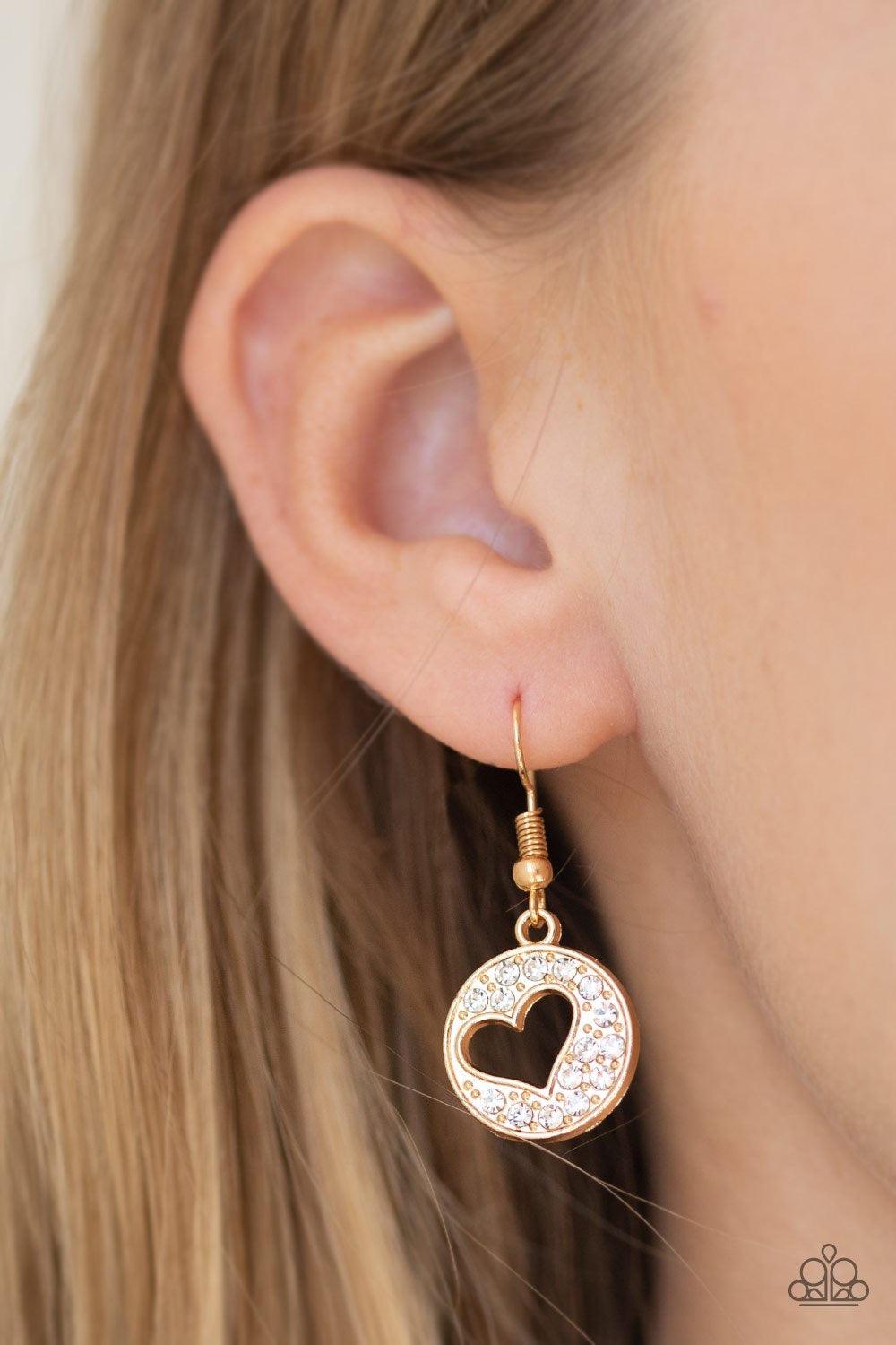 Paparazzi Accessories Heartbeat Retreat - Gold Radiating with glittery white rhinestones, an airy heart pendant swings from the bottom of a glistening gold chain below the collar for a flirty flair. Features a toggle clasp. Sold as one individual necklace