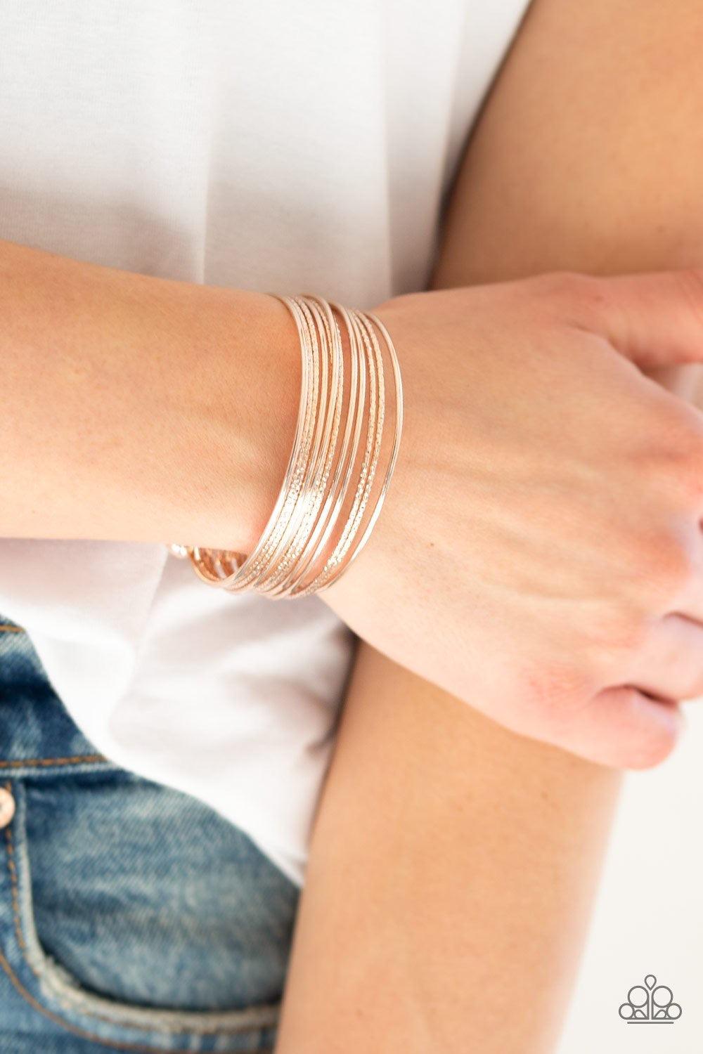 Paparazzi Accessories Endlessly Empress - Gold Attached to two rose gold rods, smooth and textured rose gold bars curl around the wrist, creating the illusion of stacked bangles. Sold as one individual bracelet. Jewelry