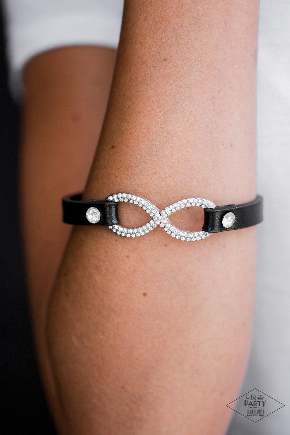 Paparazzi Accessories Innocent Till Proven Guilty - White A skinny strip of black leather attaches to a silver infinity symbol encrusted in glittery rhinestones. Flanked by two dazzling solitaire rhinestones, the glitzy design creates an incandescent cent