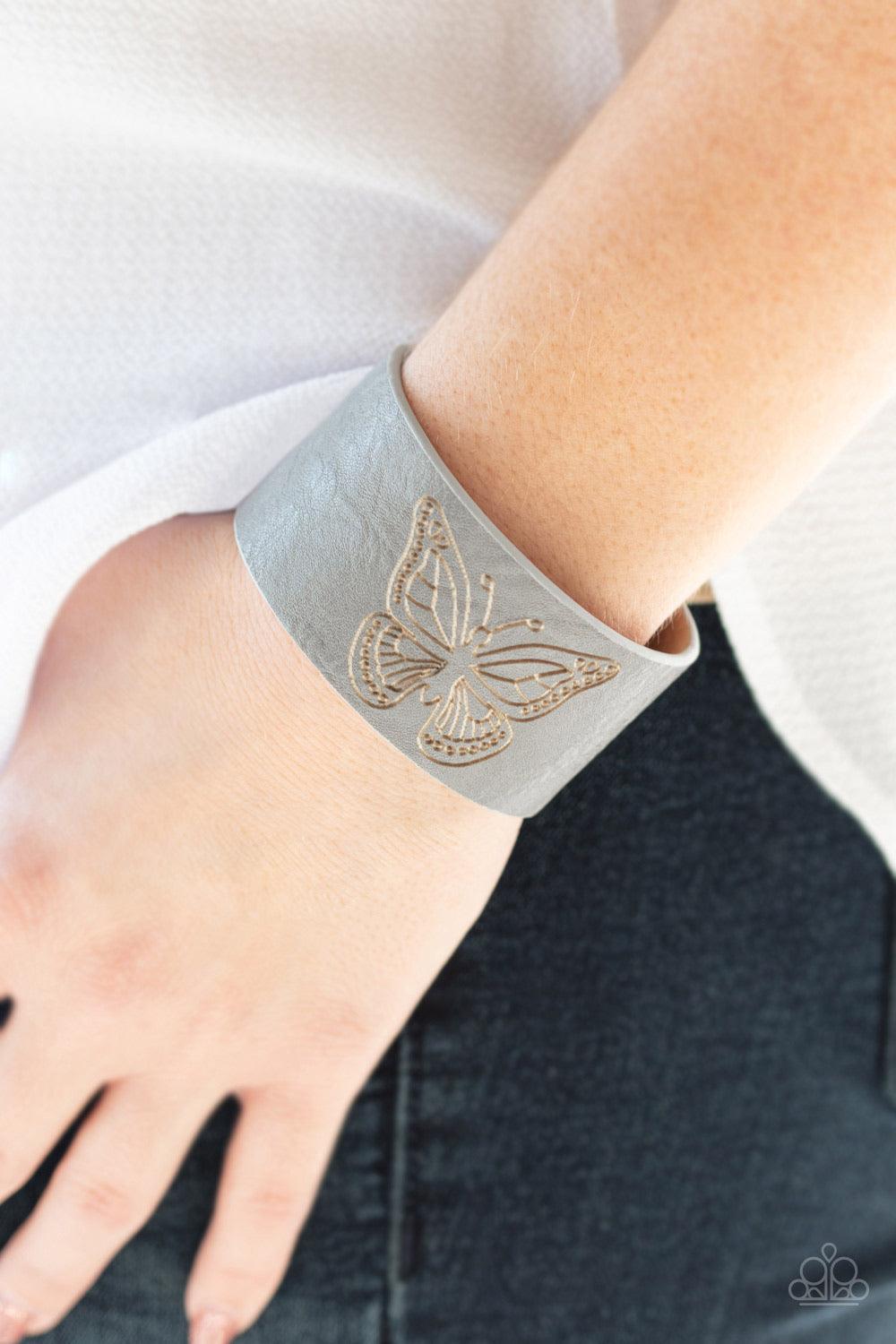 Paparazzi Accessories Flirty Flutter - Silver Stamped in a whimsical butterfly, a rustic piece of gray leather wraps around the wrist for a seasonal flair. Features an adjustable snap closure. Sold as one individual bracelet. Jewelry