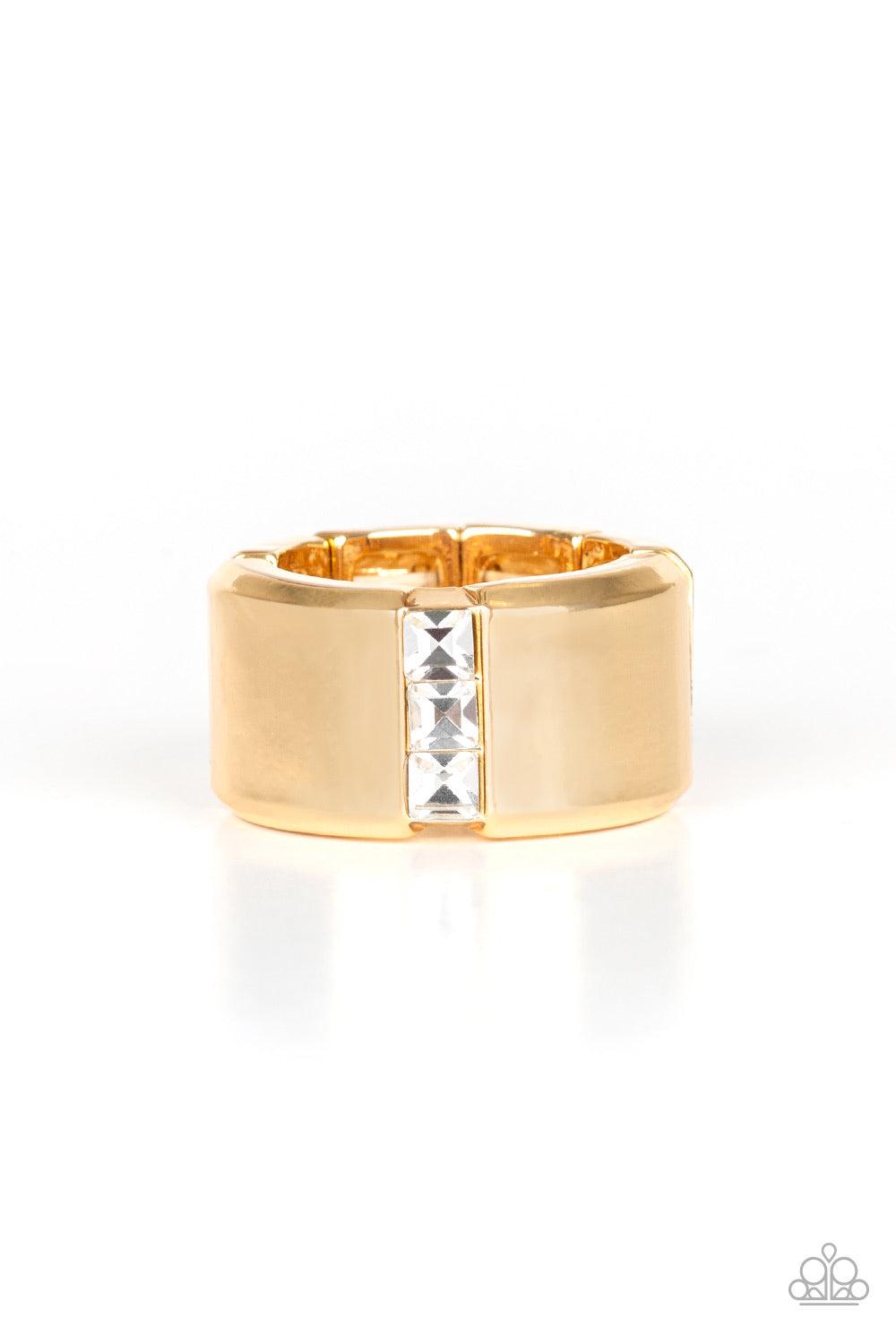 Paparazzi Accessories The Graduate - Gold A single row of square-cut white rhinestones stack down the center of a thick gold band. Features a stretchy band for a flexible fit. Jewelry