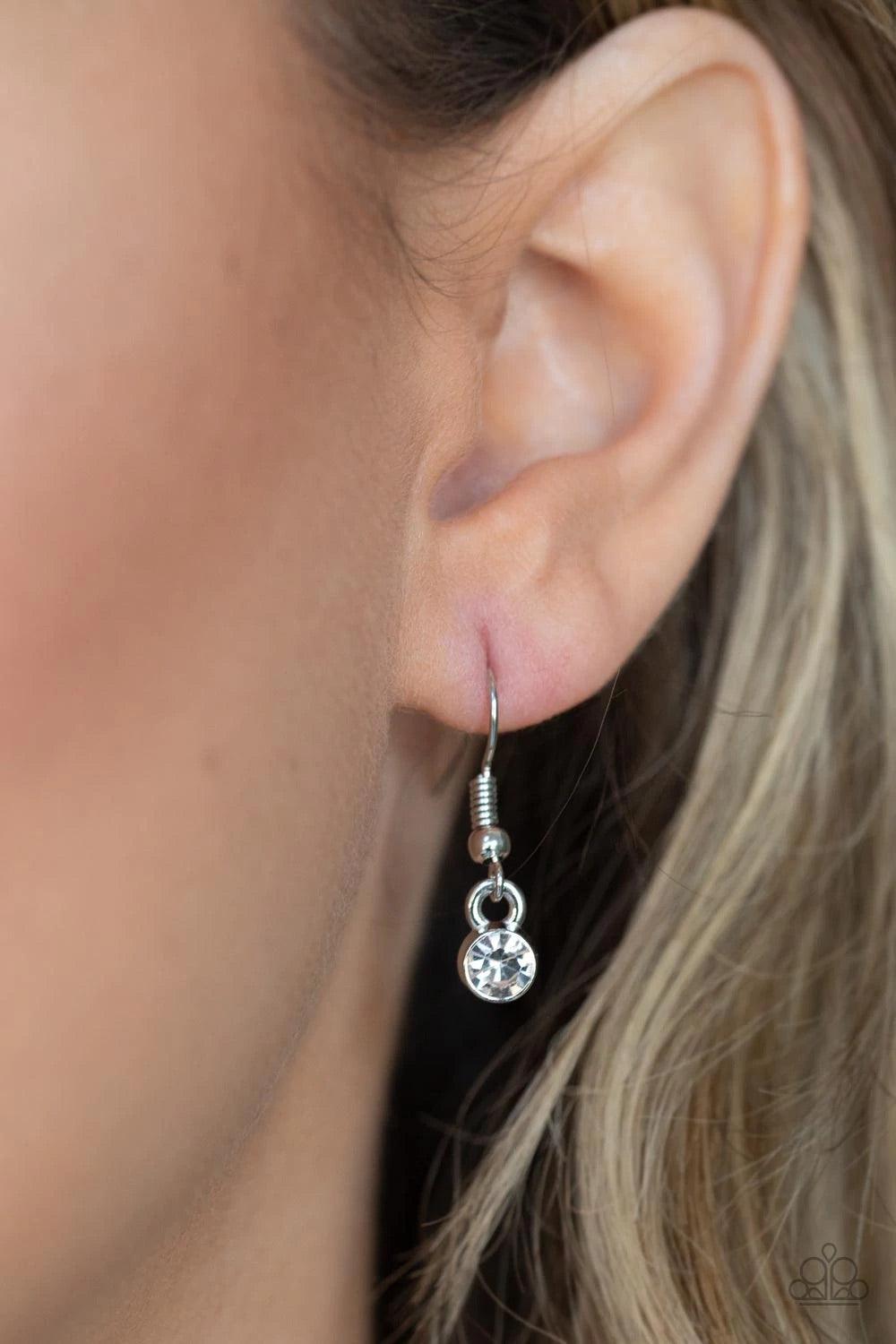 Paparazzi Accessories BLING Into Focus - Silver Infused with a pair of classic silver beads and a white rhinestone encrusted accent, lengthened shimmery silver leather cording knots around a bold silver hoop for a knockout look. Features an adjustable cla