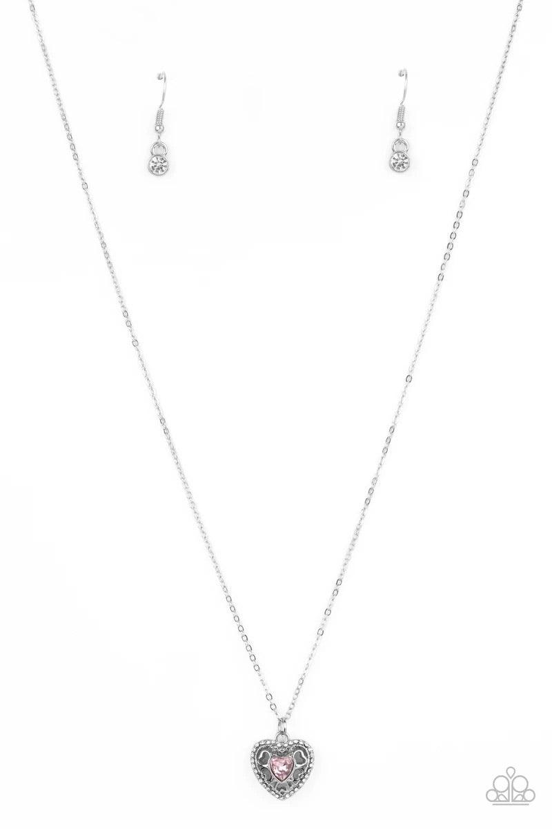 Paparazzi Accessories Treasures of the Heart - Pink Bordered in dainty white rhinestones, an airy silver locket inspired pendant is dotted with a pink heart-shaped rhinestone as it flirtatiously glides along a dainty silver chain below the collar. Feature