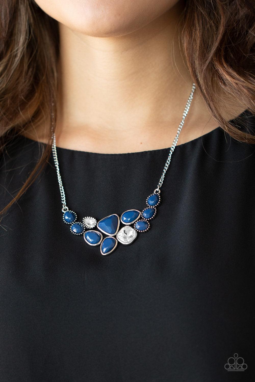 Paparazzi Accessories Breathtaking Brilliance - Blue Featuring smooth and studded silver frames, a collection of teardrop, oval, and triangular blue beads coalesce with matching white rhinestones below the collar for a glamorous pop of collar. Features an