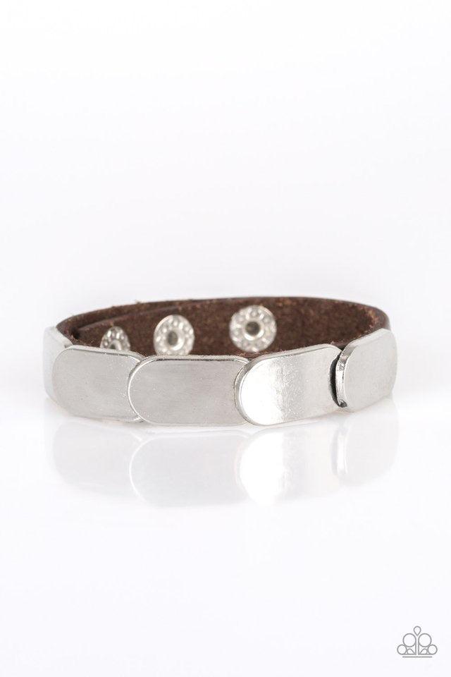 Paparazzi Accessories Off-Road Rally - Brown Overlapping silver frames are studded in place across a skinny brown leather band for a rugged look Features an adjustable snap closure. Jewelry