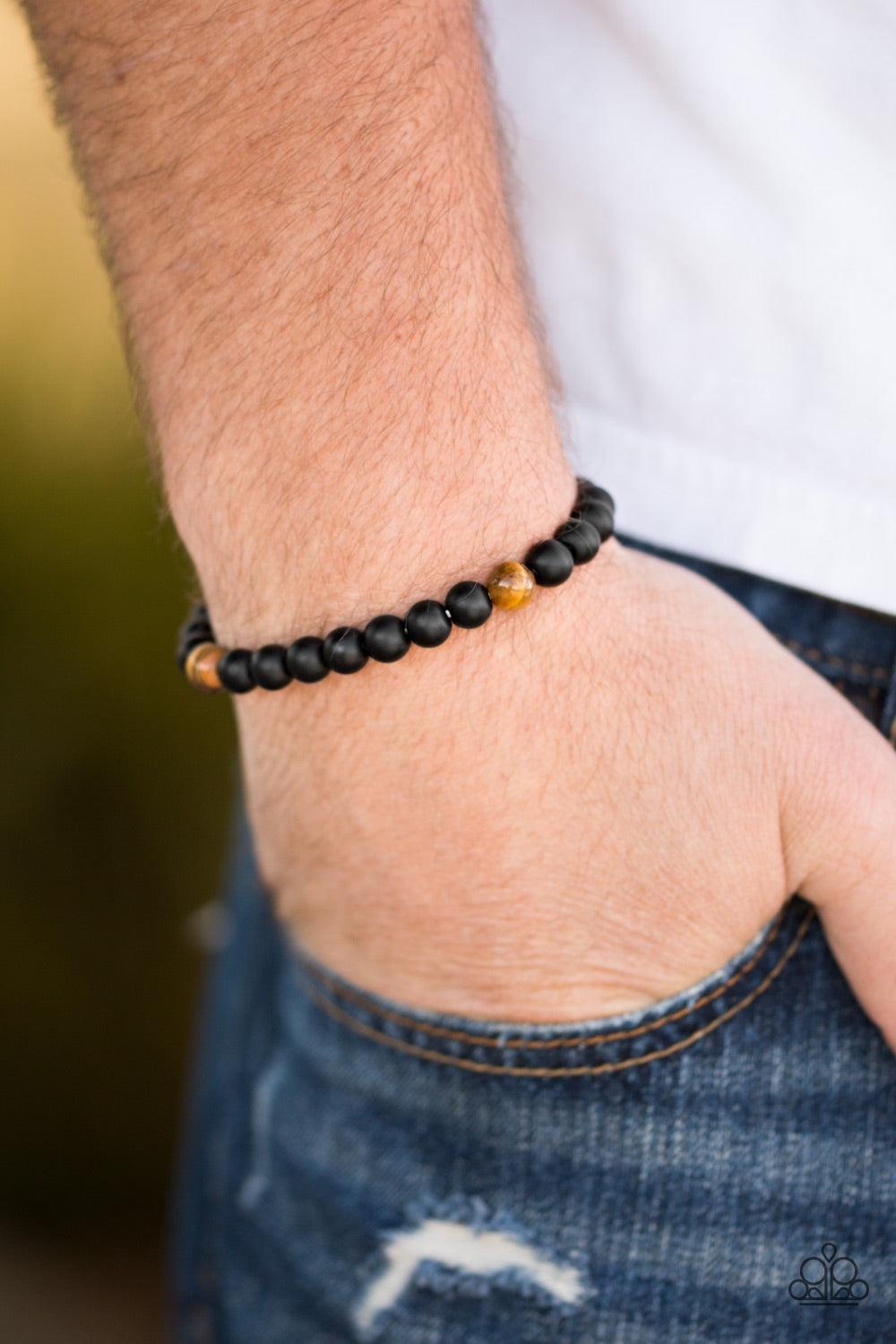 Paparazzi Accessories Harmony - Brown Brushed in a matte finish, glassy black beads are threaded along a stretchy elastic band for a seasonal look. Three Tiger's Eye stones are sprinkled between the beads for an earthy look. Jewelry
