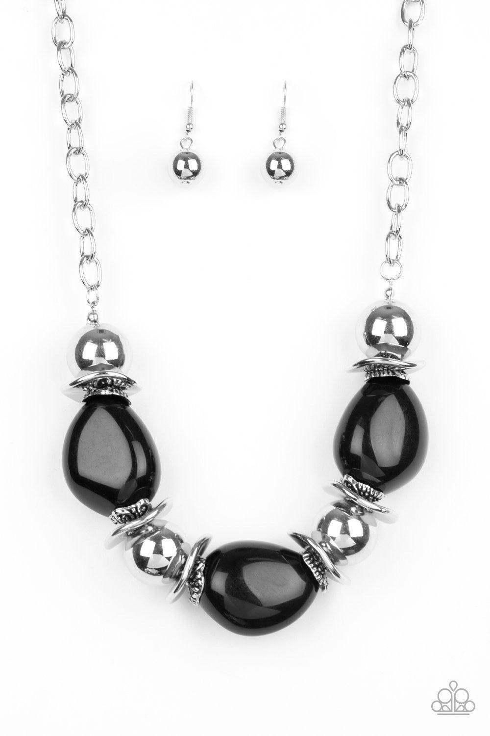 Paparazzi Accessories Vivid Vibes ~Black A collection of over sized black beads, shiny silver beads, and beveled silver discs are threaded along an invisible wire below the collar for a vivacious look. Features an adjustable clasp closure.