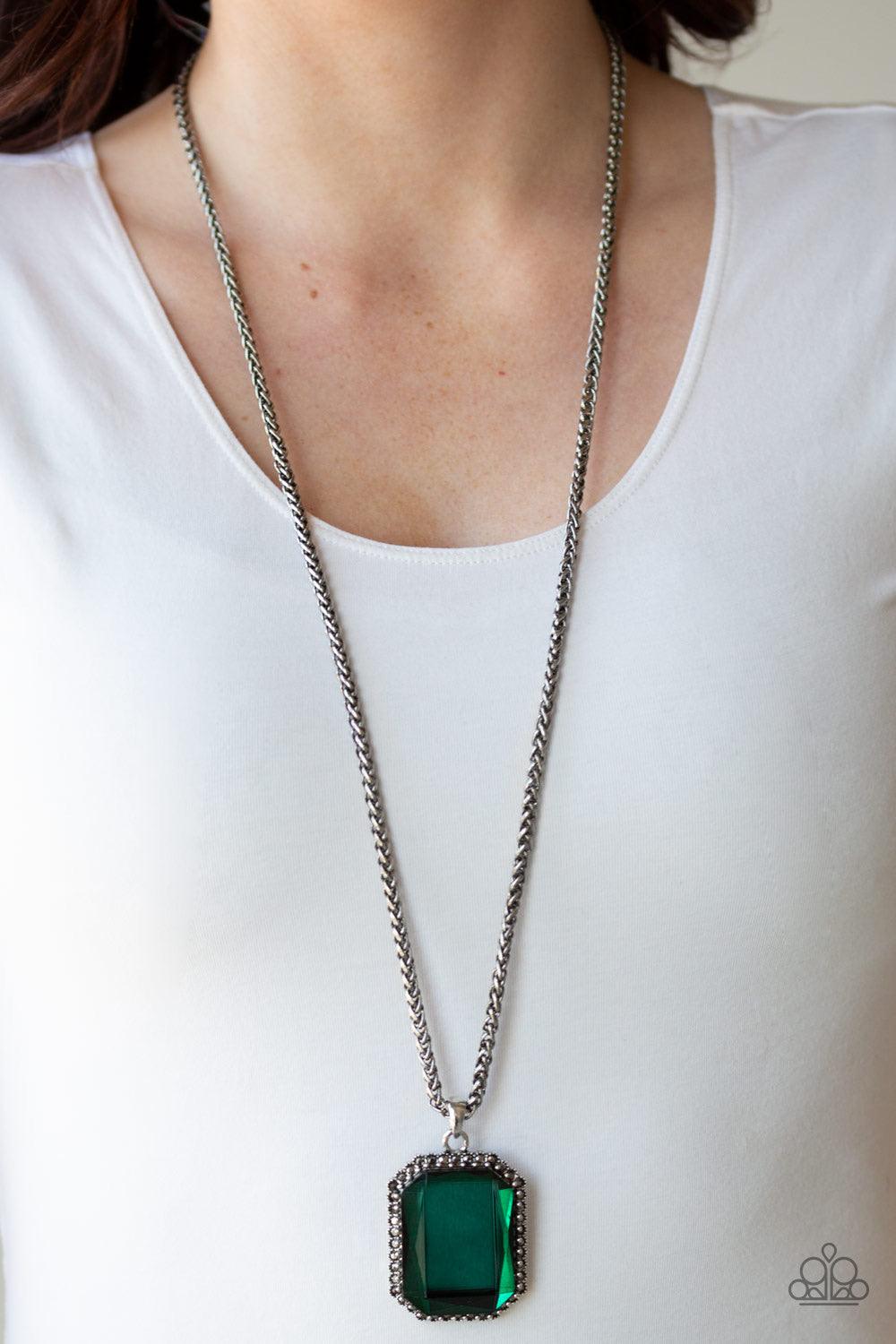 Paparazzi Accessories Let Your HEIR Down - Green Bordered in dainty hematite rhinestones, an oversized faceted green emerald style gem swings from the bottom of an antiqued silver wheat chain for a blinding look. Features an adjustable clasp closure. Jewe