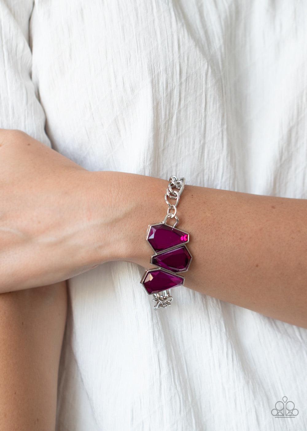 Paparazzi Accessories Raw Radiance - Pink Attached to a shiny silver chain, a trio of sparkly Pink Peacock gem-shaped rhinestones join into a glamorous centerpiece atop the wrist. Features an adjustable clasp closure. Sold as one individual bracelet. Jewe