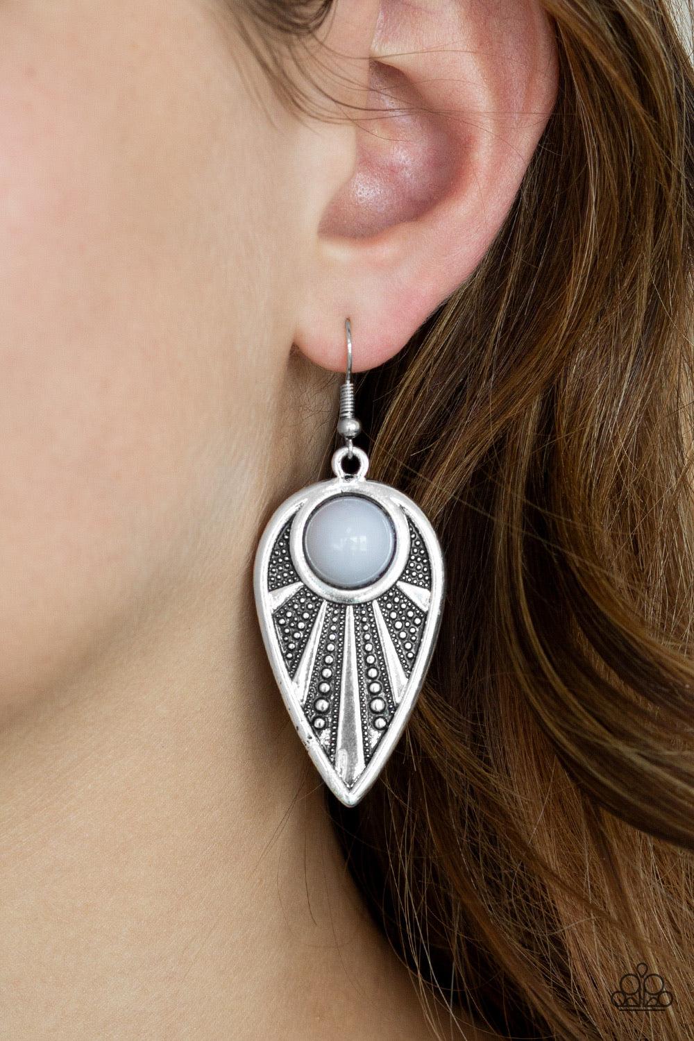 Paparazzi Accessories Take a WALKABOUT - Silver A polished gray bead is pressed into the top of an ornate silver teardrop radiating with studded textures for a tribal inspired look. Earring attaches to a standard fishhook fitting. Sold as one pair of earr