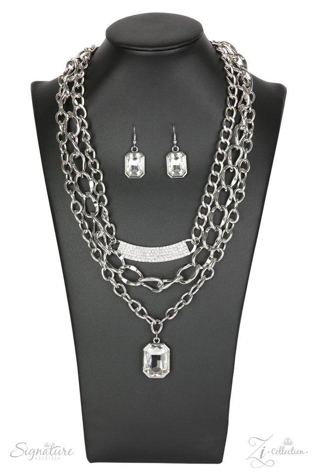 Paparazzi Accessories The Stacy A large emerald-cut rhinestone drips below a mashup of oversized silver chains, creating a beautiful contrast of industrial edge and timeless sparkle. A bowing silver bar encrusted in dazzling white rhinestones adorns the t