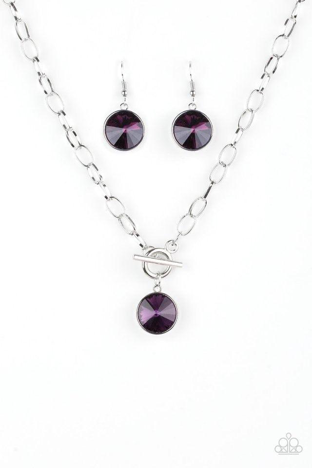 Paparazzi Accessories She Sparkles On - Purple A dramatic purple gem swings from the bottom of a shiny silver chain, creating a blinding pendant below the collar. Features a toggle closure. Jewelry