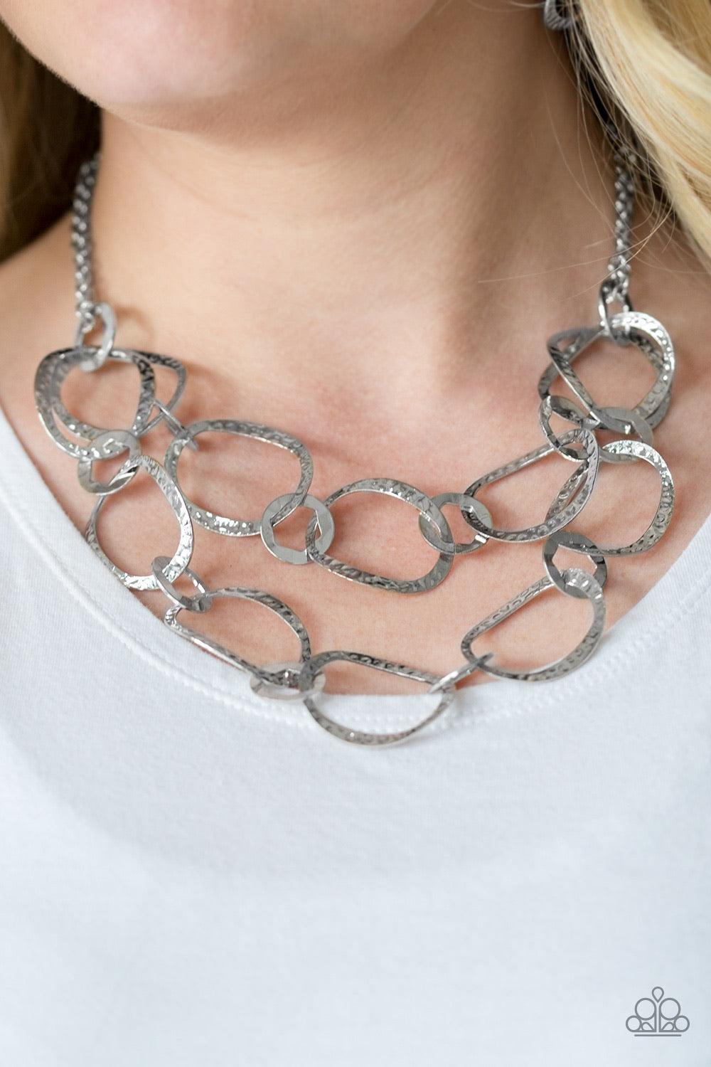 Paparazzi Accessories Circus Chic - Silver Featuring hexagonal centers, dainty silver rings link together two rows of hammered silver frames. The layered rows drape just below the collar for a refined look. Features an adjustable clasp closure. Sold as on