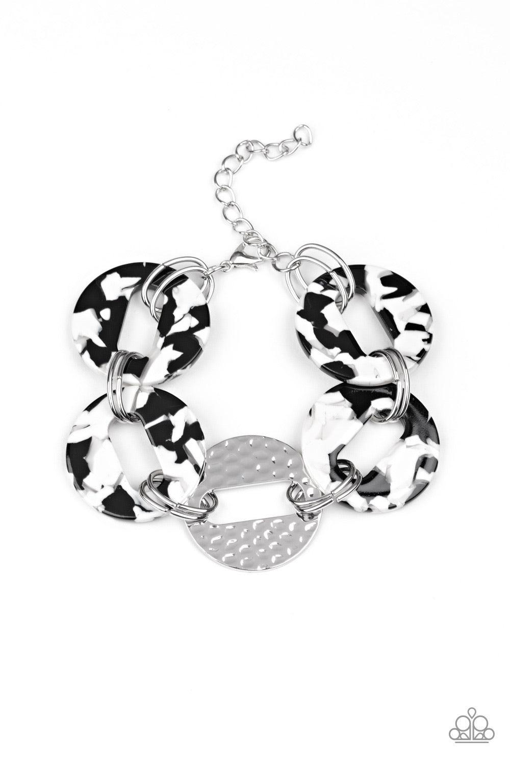 Paparazzi Accessories Retro Recharge - White Featuring airy circular shapes, hammered silver frames link with speckled black and white acrylic frames around the wrist for a colorfully retro look. Features an adjustable clasp closure. Sold as one individua
