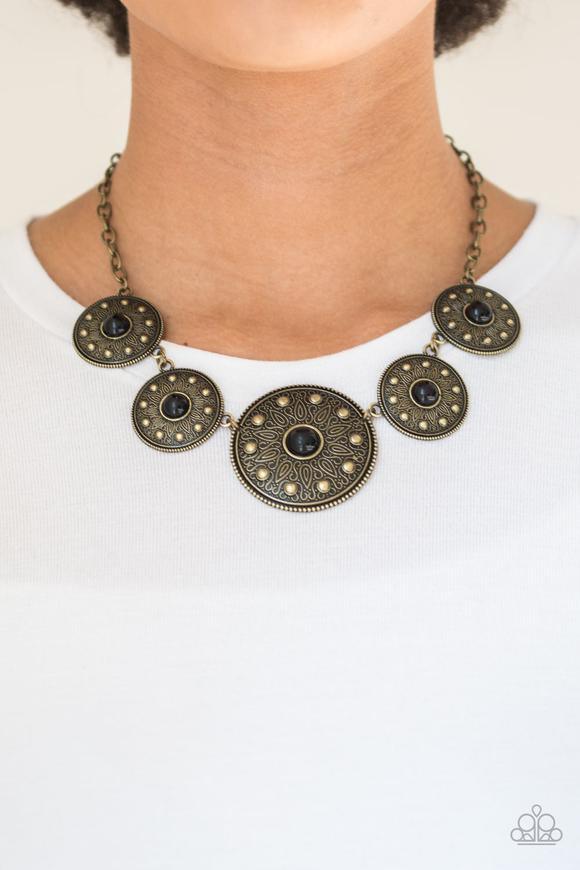 Paparazzi Accessories Hey, SOL Sister - Black Gradually increasing in size near the center, round brass frames radiating with sunburst patterns link below the collar. Infused with shiny brass studs, the tribal inspired frames are dotted with black beaded