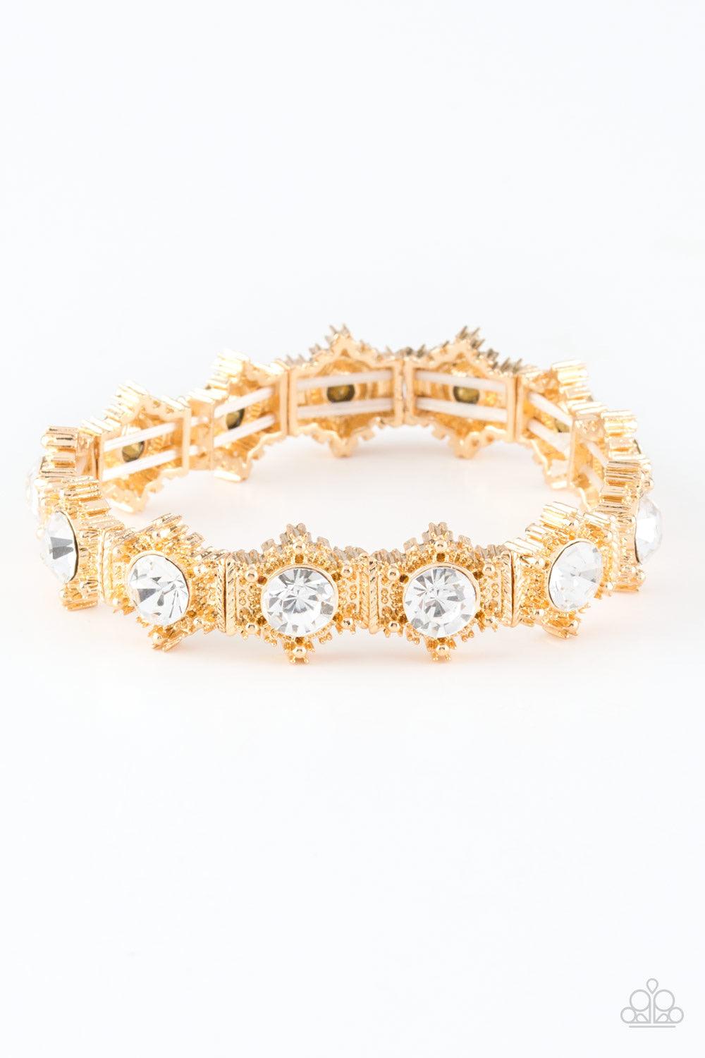 Paparazzi Accessories Strut Your Stuff - Gold Featuring glittery white rhinestone centers, ornate golden frames are threaded along stretchy bands, linking across the wrist for a refined look. Jewelry