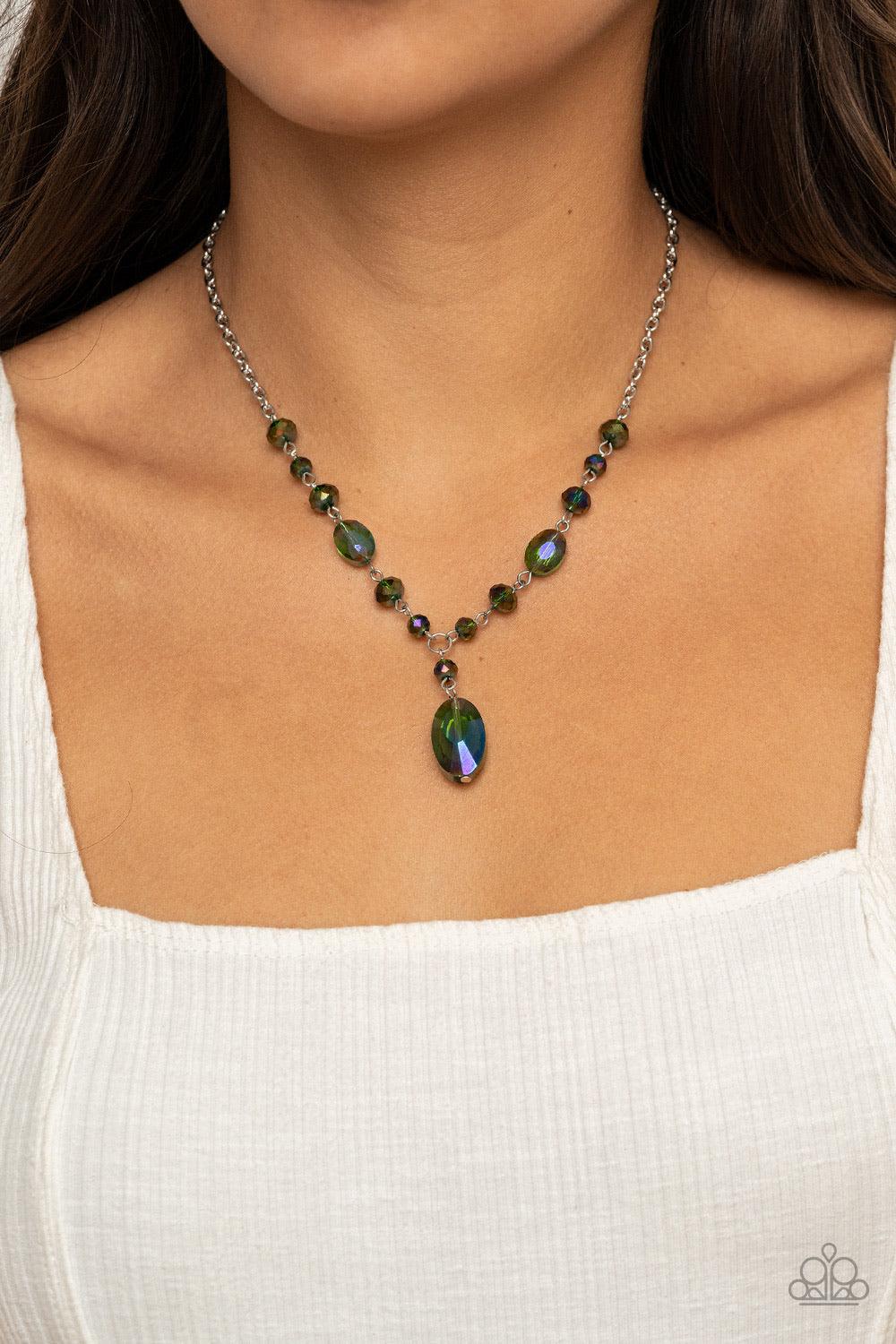 Paparazzi Accessories Fashionista Week - Green Featuring an iridescent shimmer, an oval green crystal-like bead swings from the bottom of a matching crystal-beaded chain, creating an elegantly extended pendant below the collar. Features an adjustable clas