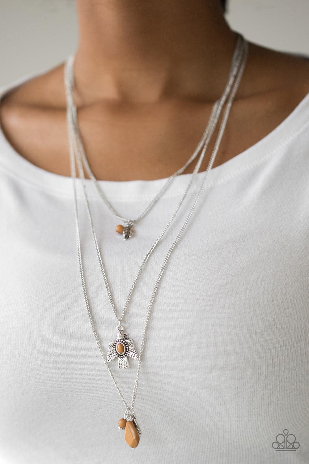 Paparazzi Accessories Soar With The Eagles - Brown Infused with mismatched Meerkat beading, a shimmery silver feather charm and decorative eagle pendant layer down the chest for a colorful Southwestern inspired look. Features an adjustable clasp closure.