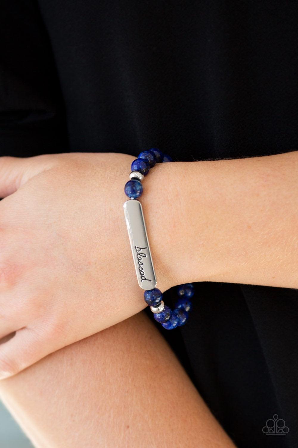 Paparazzi Accessories Born Blessed - Blue Infused with dainty silver accents, a collection of speckled blue stones are threaded along a stretchy band. A glistening silver frame engraved with the word, "blessed" adorns the center for a seasonal finish. Jew