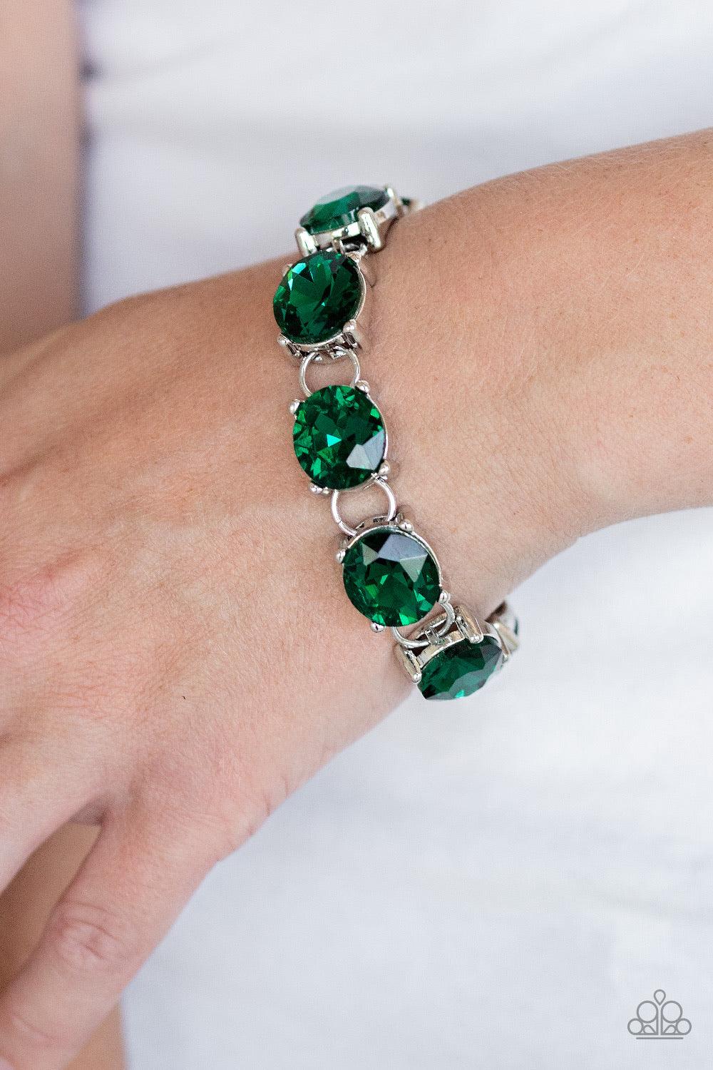 Paparazzi Accessories Mind Your Manners - Green Featuring sleek silver settings, a blinding collection of oversized green rhinestones dramatically link across the wrist for a glamorous fashion. Features an adjustable clasp closure. Sold as one individual