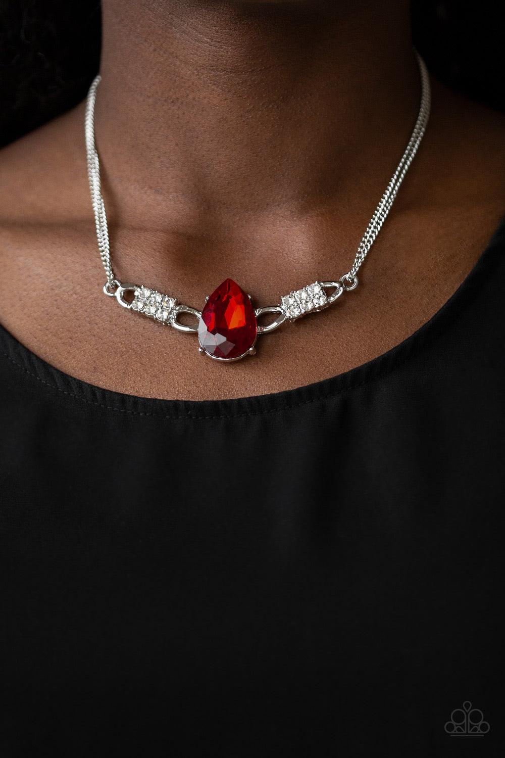 Paparazzi Accessories Way To Make An Entrance ~Red Cut into an alluring teardrop, an oversized red rhinestone gem attaches to bold silver frames radiating with glassy white rhinestones. The dramatic pendant attaches to doubled silver chains, swinging hori