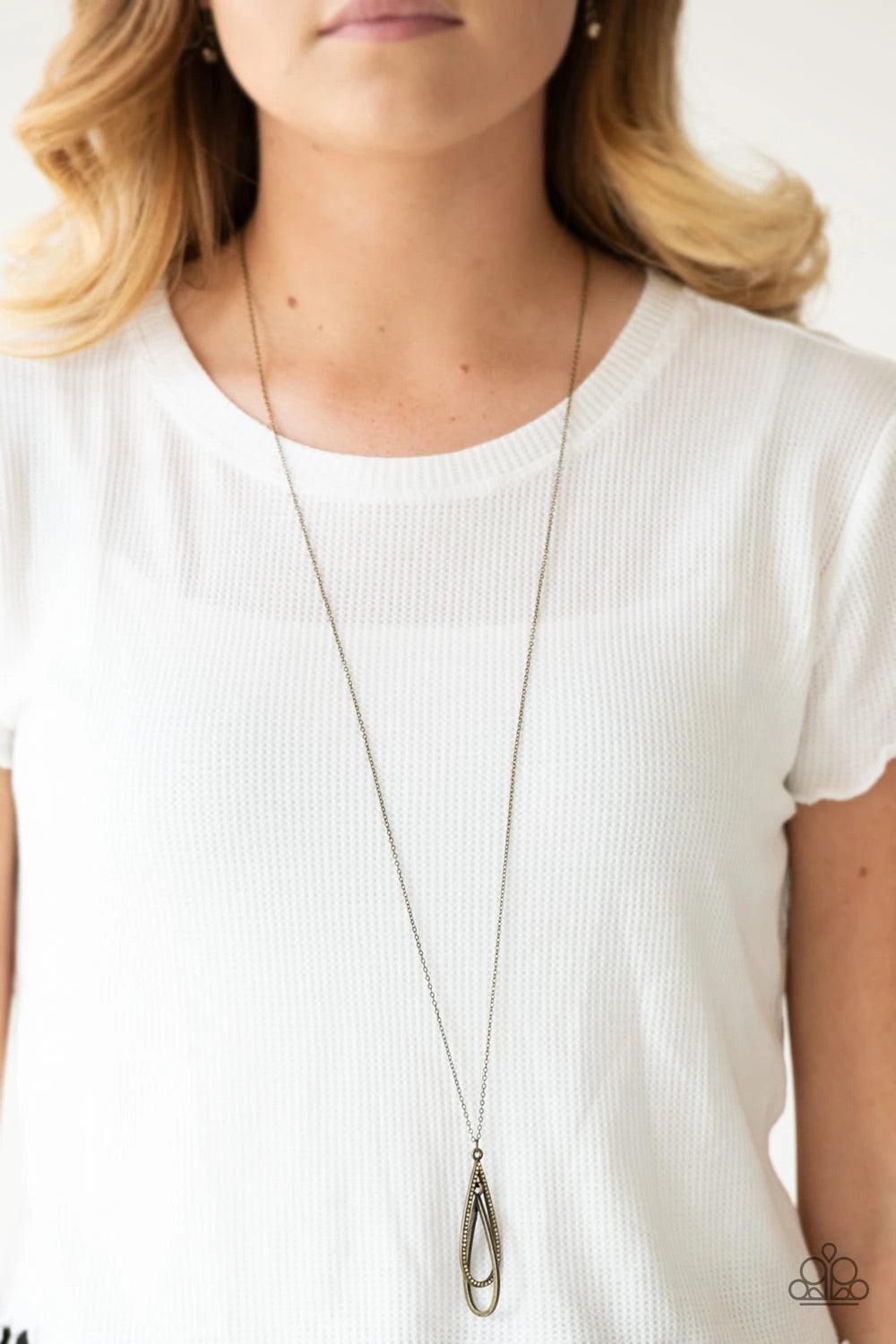 Paparazzi Accessories Step Into The Spotlight - Brass Infused with an elegantly elongated brass chain, a topaz rhinestone encrusted teardrop interlocks with a smooth brass teardrop, creating a refined pendant. Features an adjustable clasp closure. Sold as