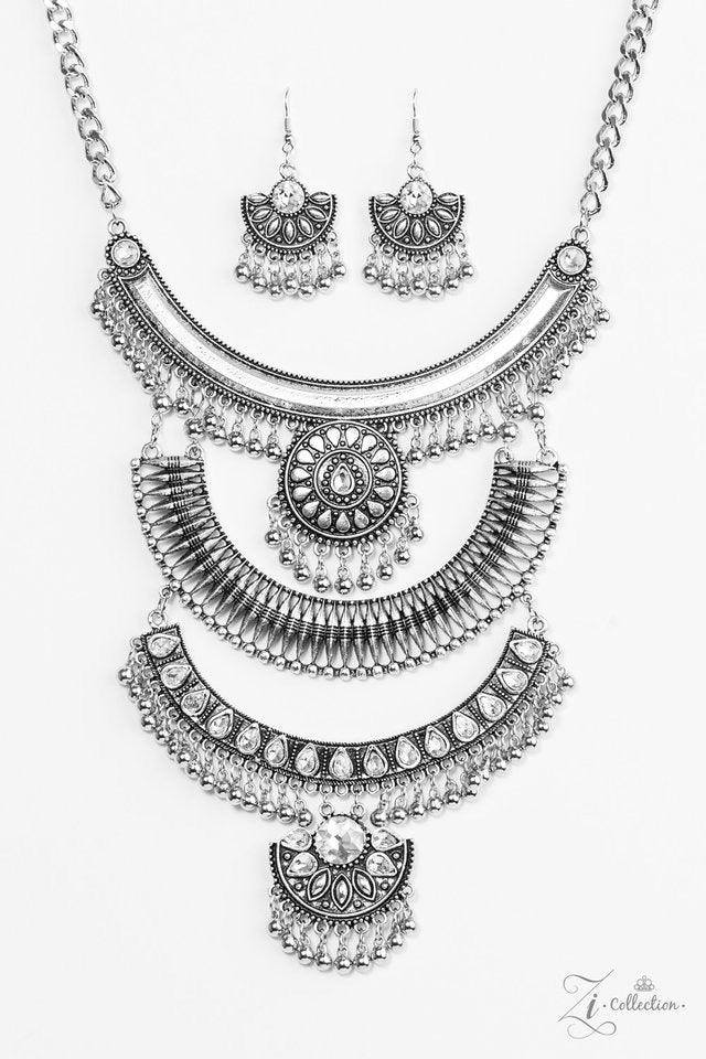 Paparazzi Accessories Legend Three oversized crescent plates connect vertically down the chest, creating a dramatically stacked pendant. Infused with shimmery tribal patterns and layers of flirty beaded fringe, glittery white rhinestones are haphazardly p