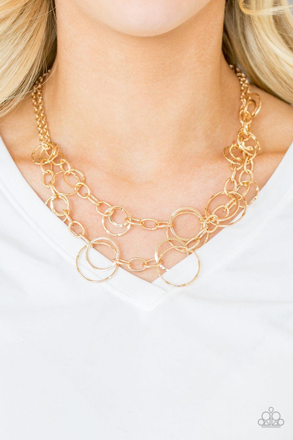 Paparazzi Accessories Urban Center - Gold Mismatched gold hoops and rings link into two shimmery rows below the collar for a bold industrial look. Features an adjustable clasp closure. Jewelry