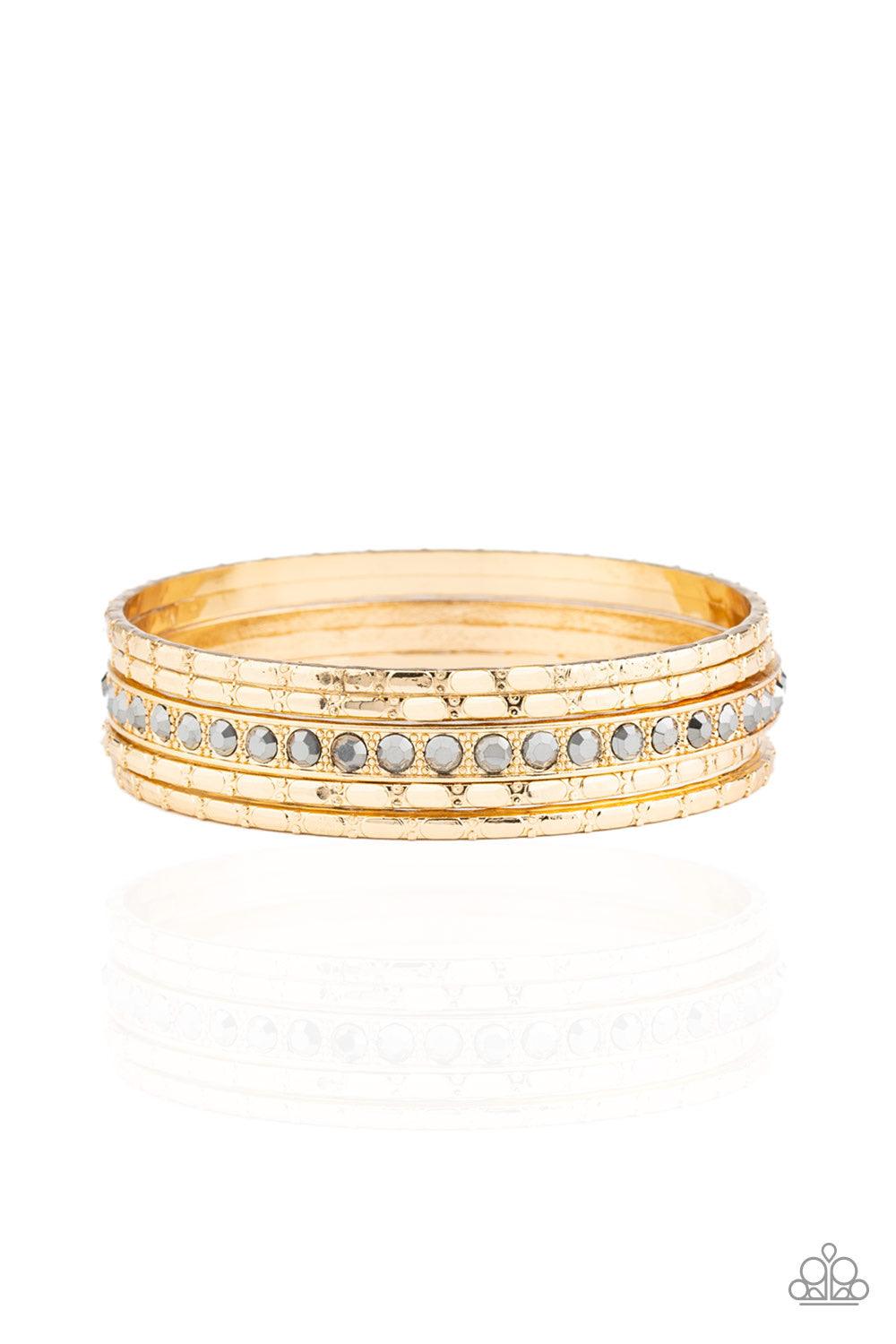 Paparazzi Accessories Glitzy Grunge - Gold A single hematite rhinestone encrusted bangle joins four textured gold bangles, creating an edgy stack of shimmer across the wrist. Jewelry